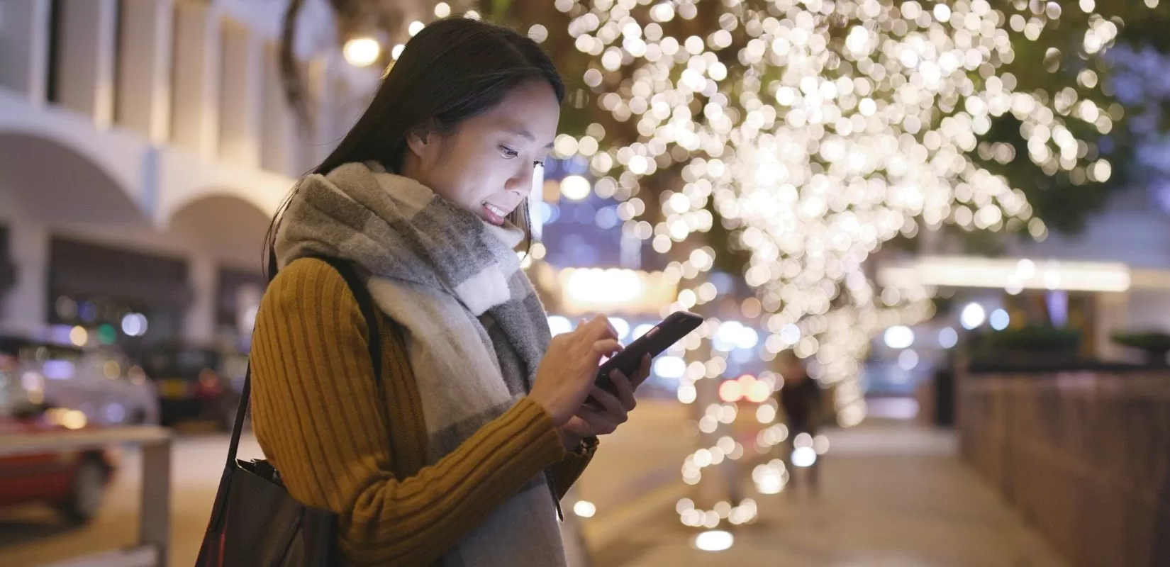 a woman using her smartphone during christmas time